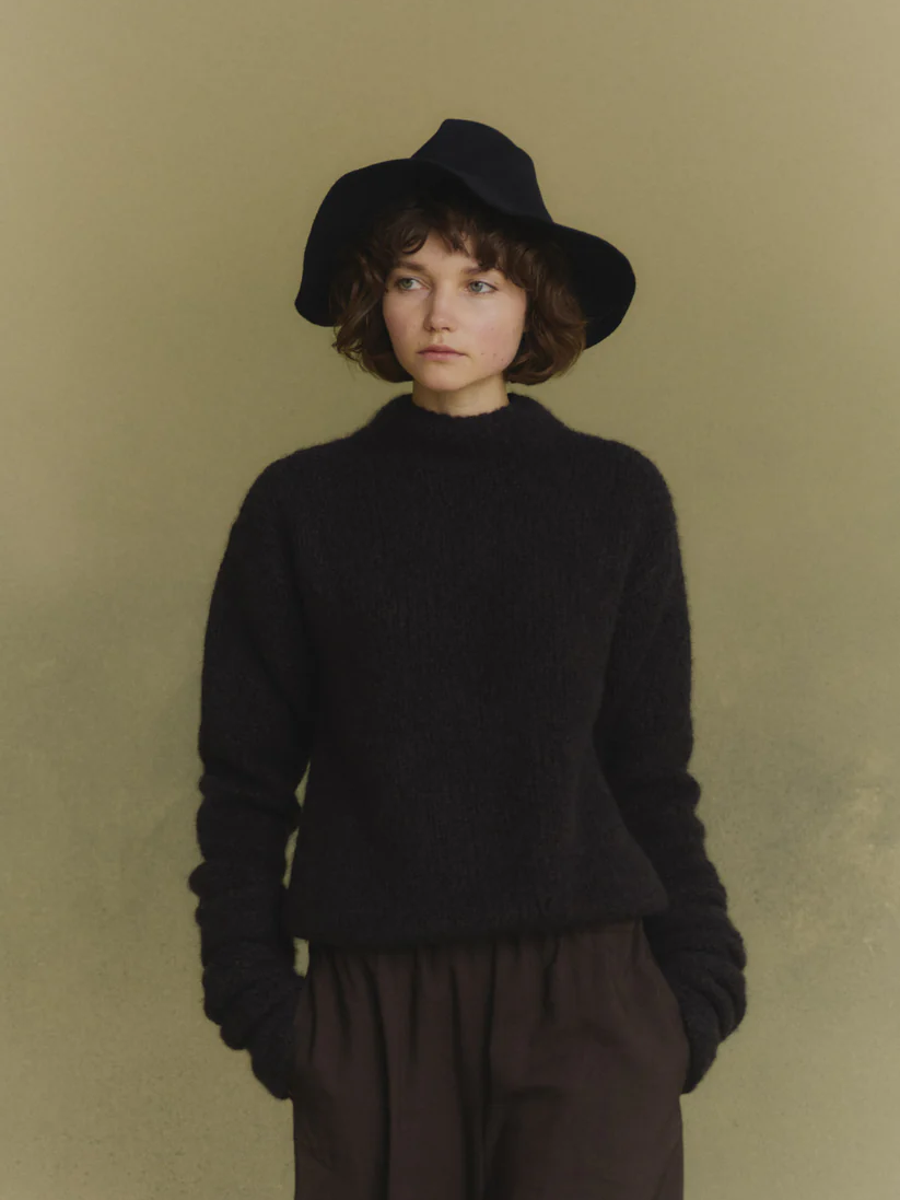 Navy knitwear worn by a person, showing the knitwear's fit