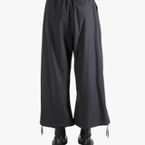 Black pants worn by a person, showing the pants' fit