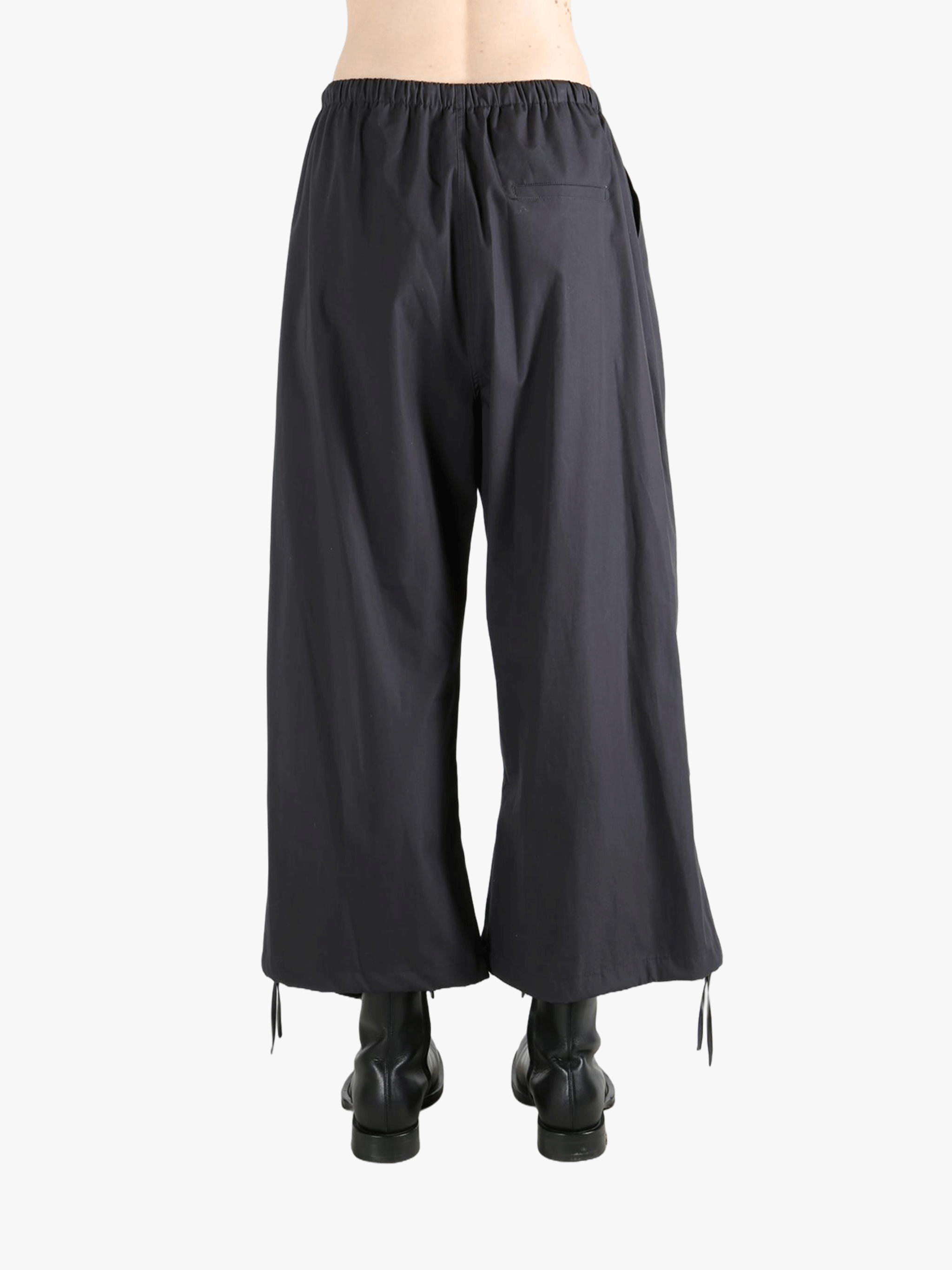 Black pants worn by a person, showing the pants' fit