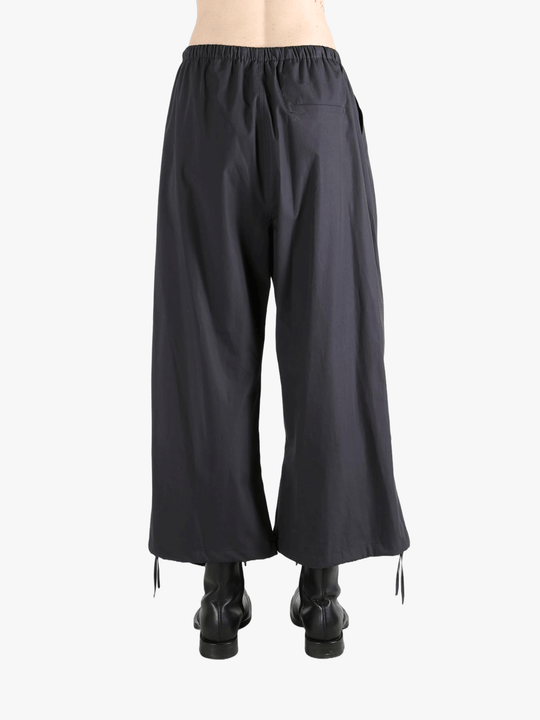 Black pants worn by a person, showing the pants' fit