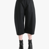 Black pants worn by a person, showing the pants' fit