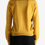 Yellow sweater worn by a person, showing the sweater's fit