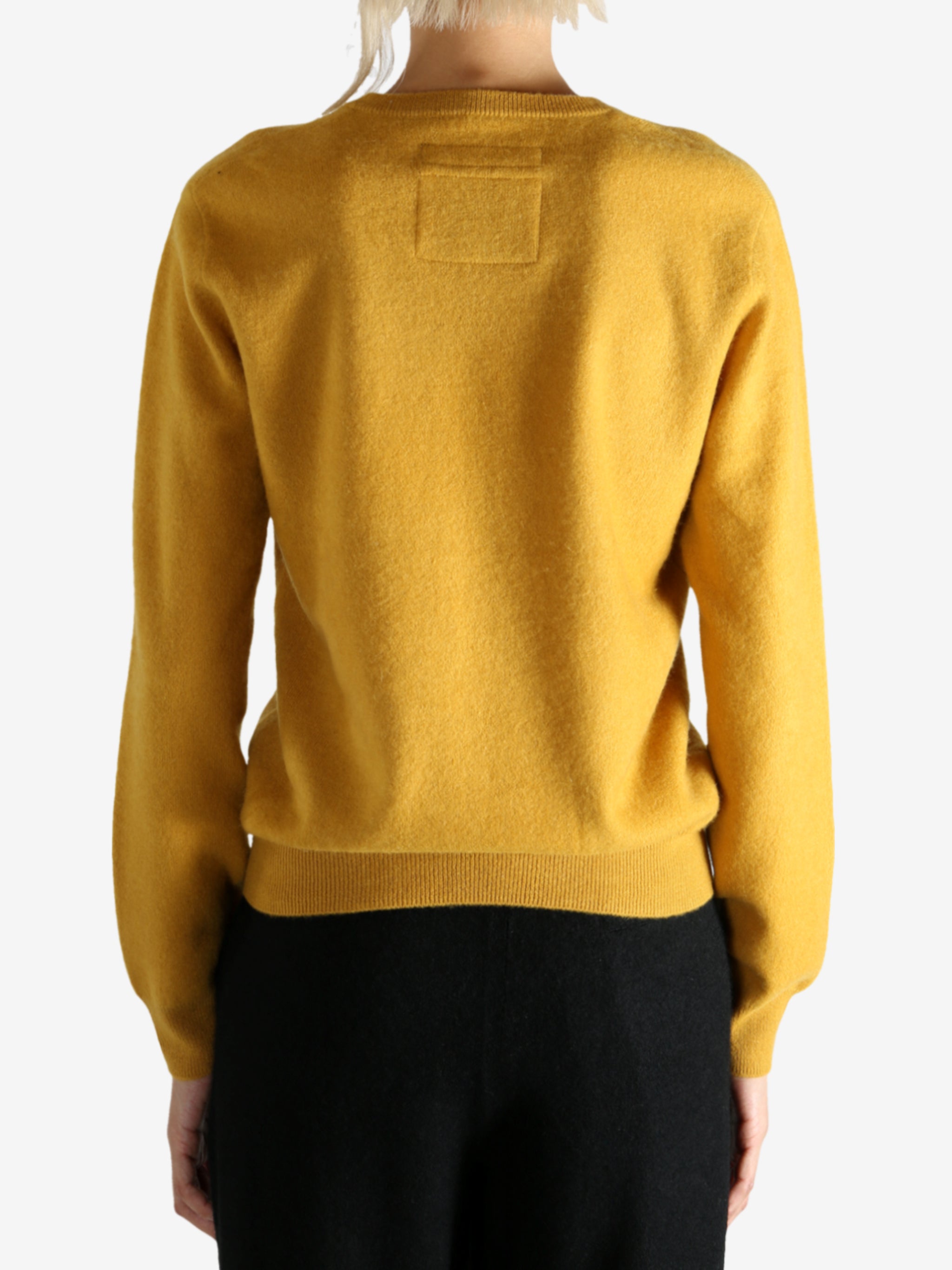 Yellow sweater worn by a person, showing the sweater's fit