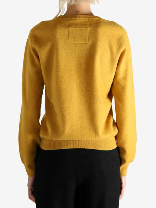 Yellow sweater worn by a person, showing the sweater's fit