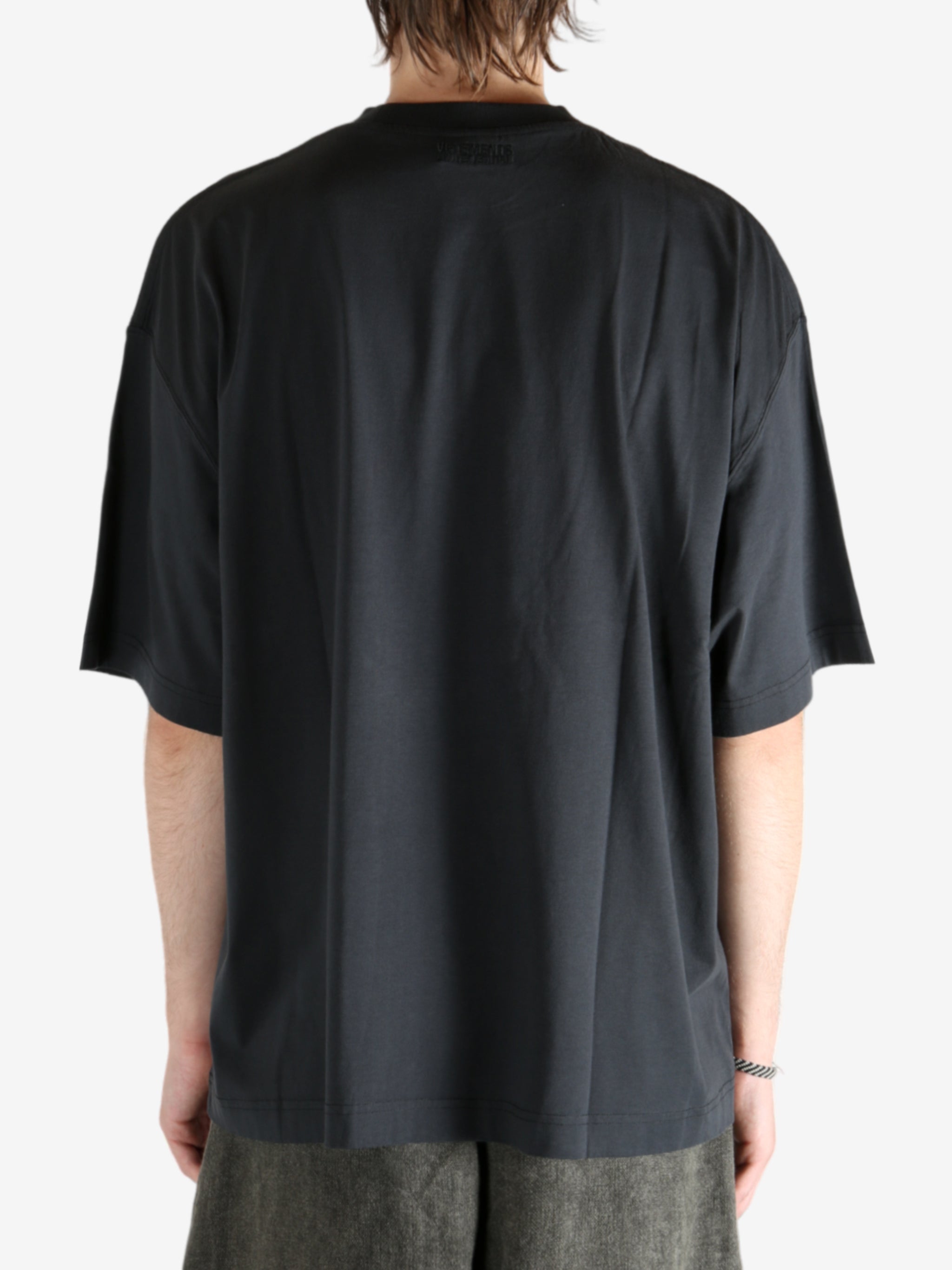 Black shirt worn by a person, showing the shirt's fit