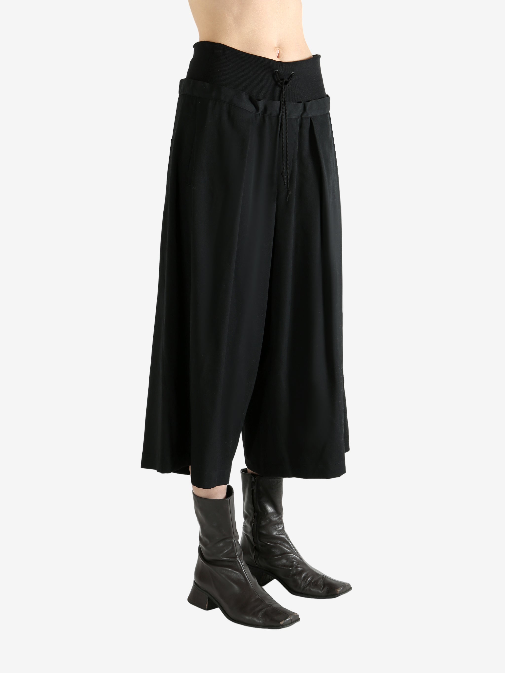 Black pants worn by a person, showing the pants fit