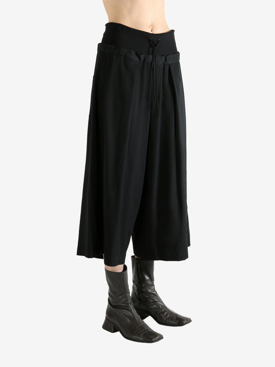 Black pants worn by a person, showing the pants fit