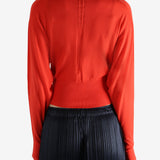 Red long-sleeve top worn by a person, showing the top fit