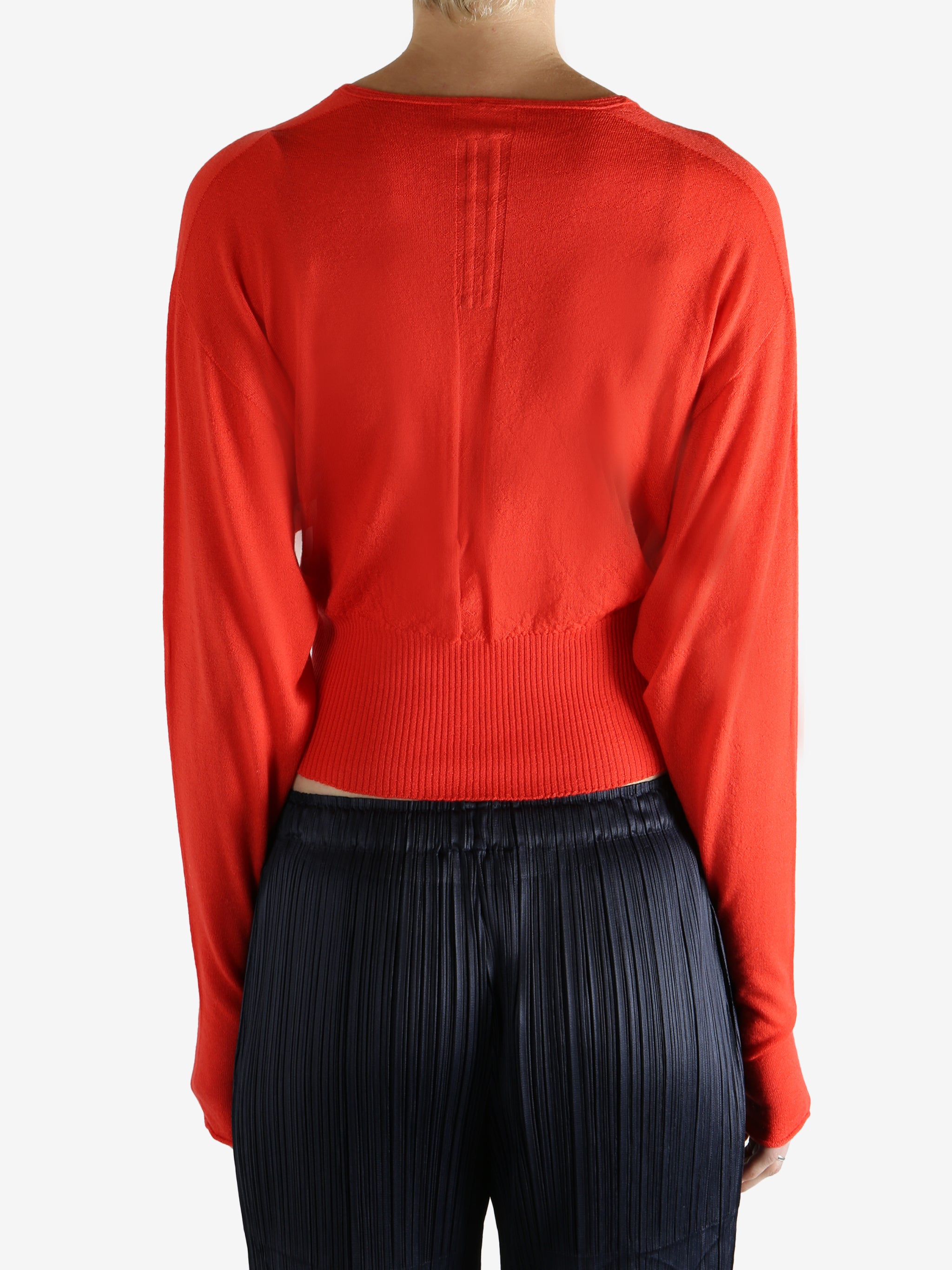 Red long-sleeve top worn by a person, showing the top fit