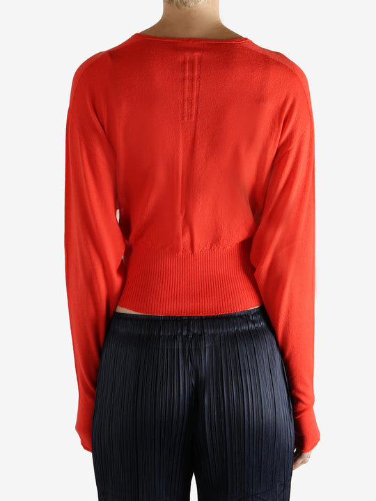 Red long-sleeve top worn by a person, showing the top fit