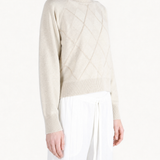 Tan knitwear worn by a person, showing the knitwear fit