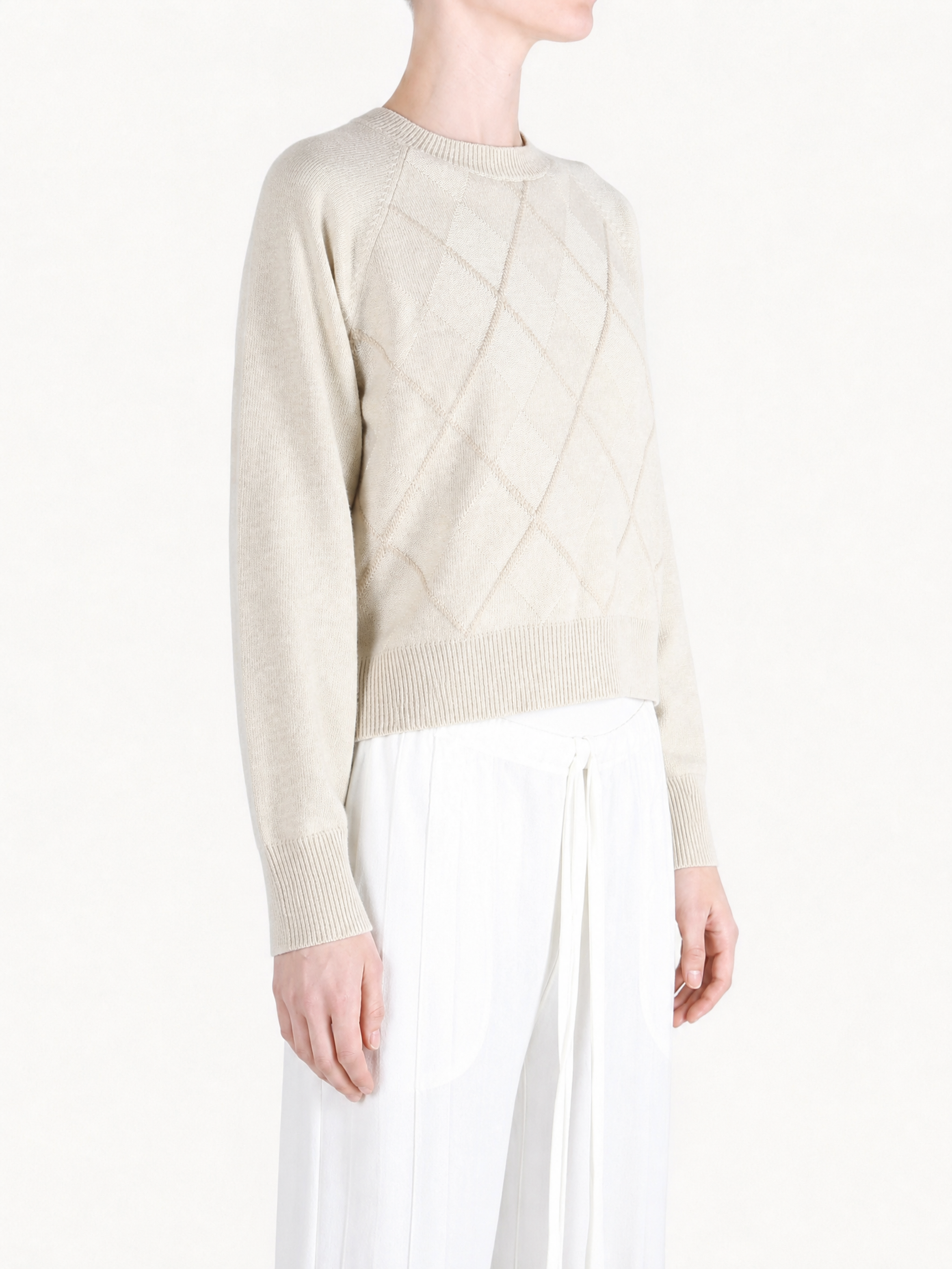 Tan knitwear worn by a person, showing the knitwear fit