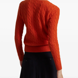 Orange knitwear worn by a person, showing the knitwear's fit