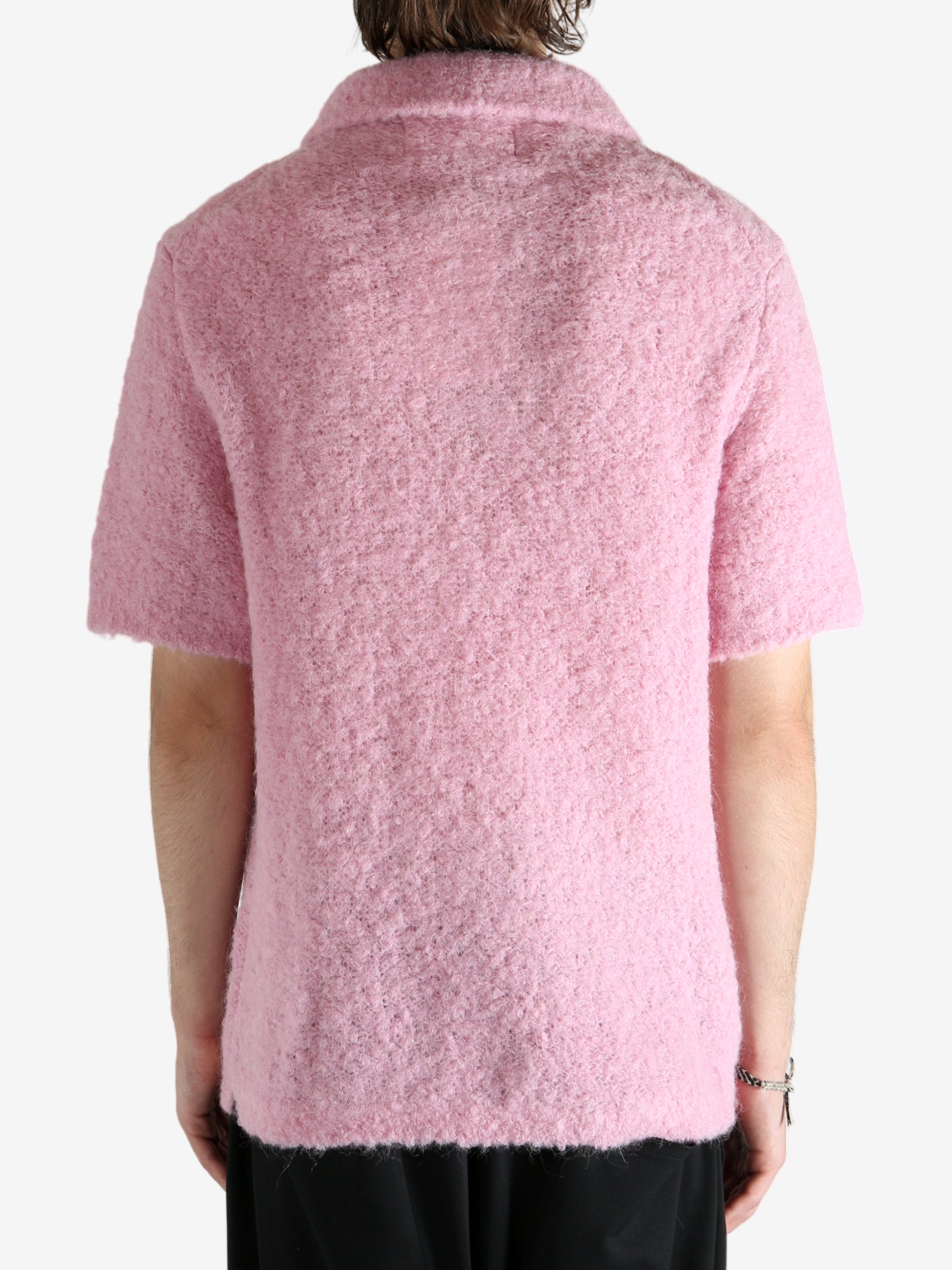Pink knitwear worn by a person, showing the knitwear's fit