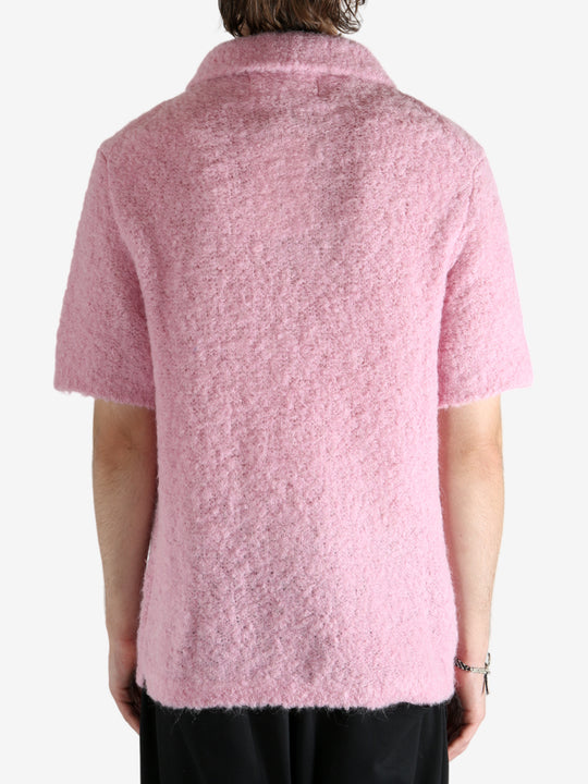 Pink knitwear worn by a person, showing the knitwear's fit