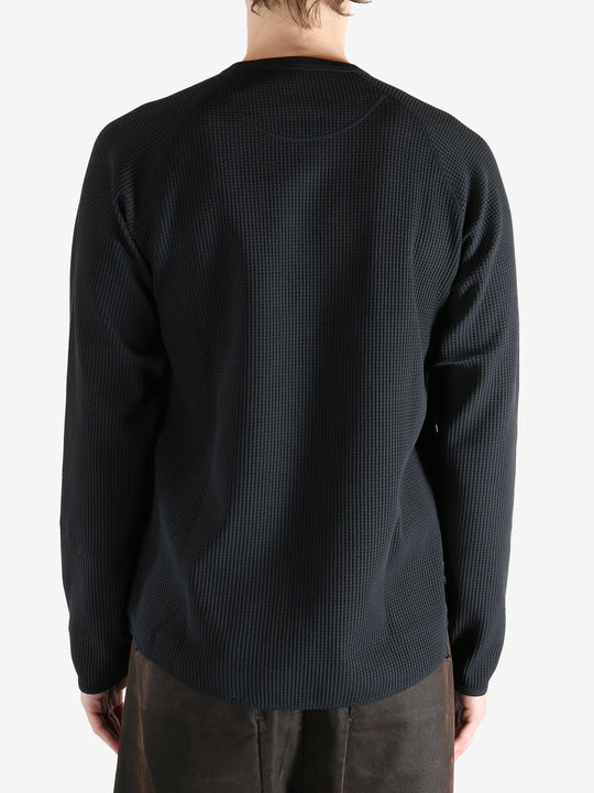 Black shirts worn by a person, showing the shirts fit