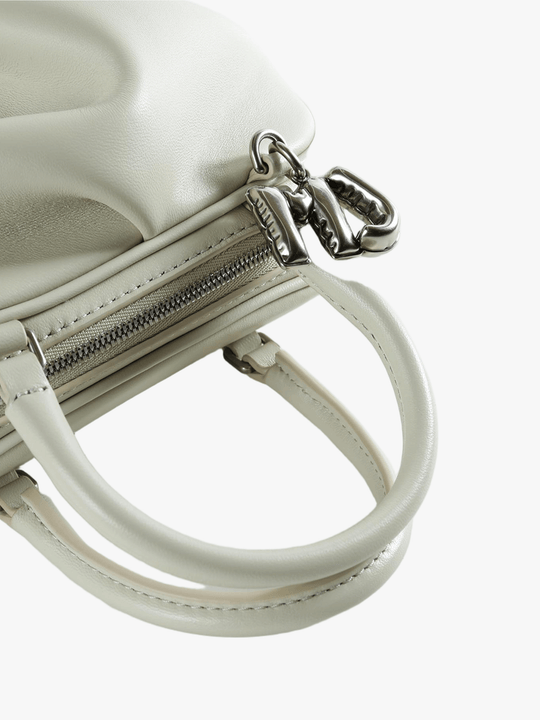 Close-up of tan bag, showing texture of the leather fabric