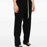 Black pants worn by a person, showing the pants' fit