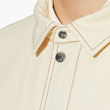 Close up of white jacket, showing texture of the cotton fabric