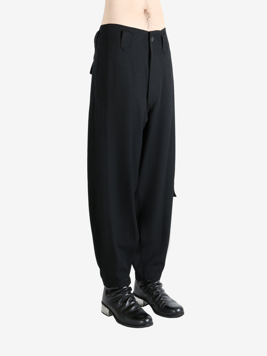 Black pants worn by a person, showing the pants's fit