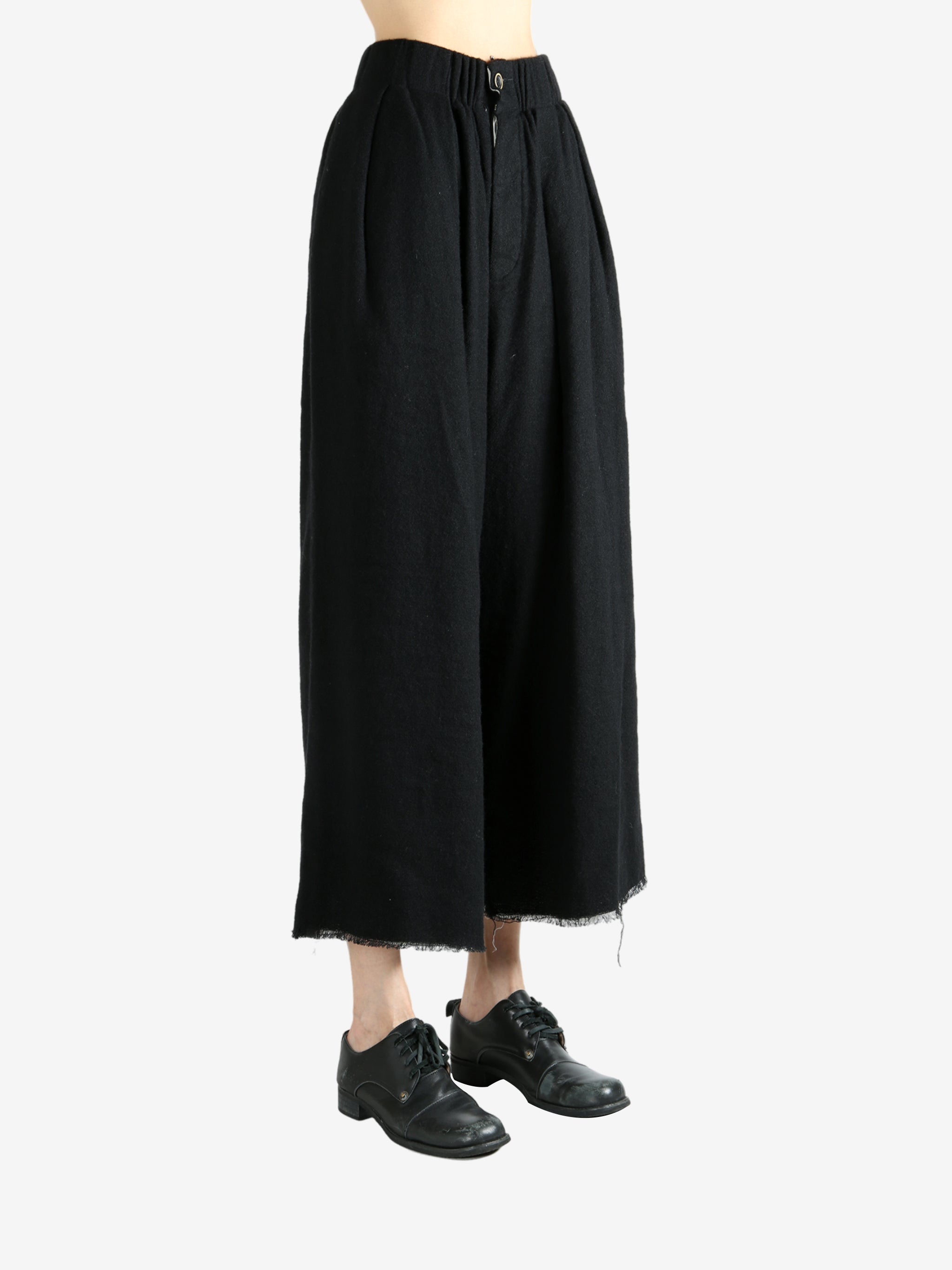 Black pants worn by a person, showing the pants fit