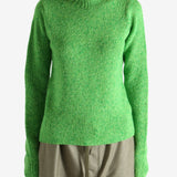Green knitwear worn by a person, showing the knitwear fit