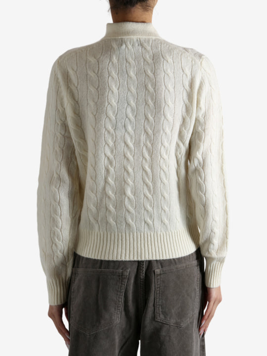 White sweater worn by a person, showing the sweater's fit