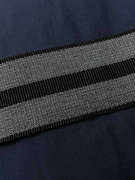 Close up of blue jackets, showing texture of the polyester and duck down fabric