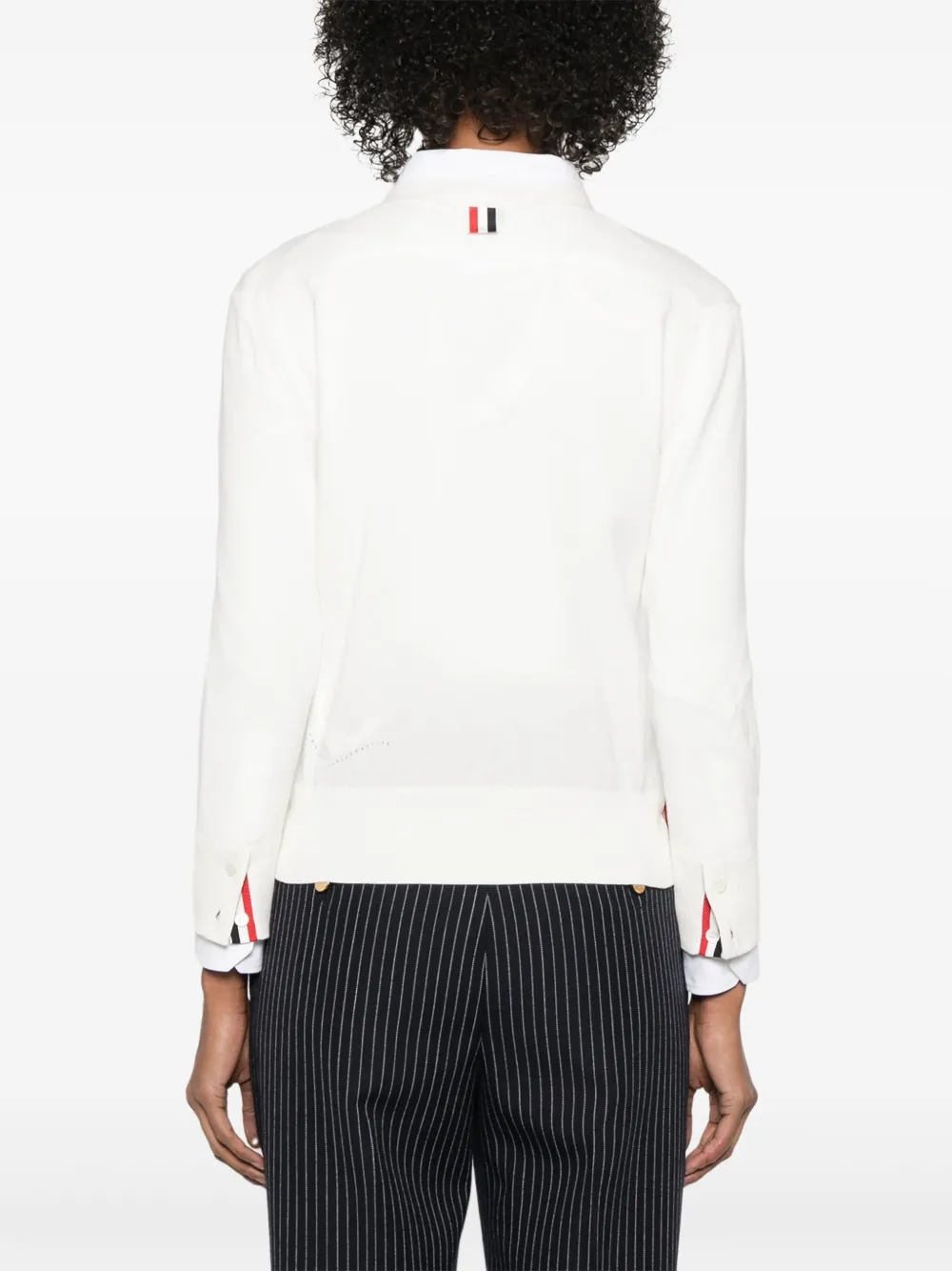 Whtie knitwear worn by a person, showing the cotton fit