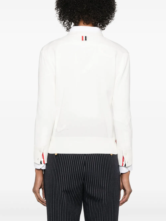 Whtie knitwear worn by a person, showing the cotton fit