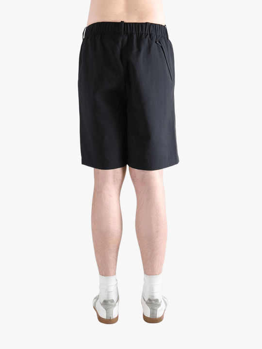 Black short worn by a person, showing the short's fit