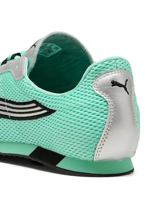 Close-up of green sneaker, showing texture of the mesh fabirc