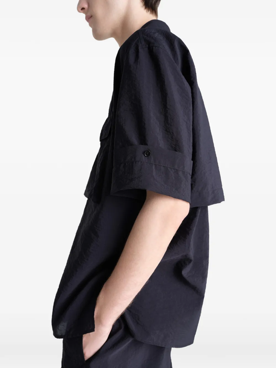 Black shirt worn by a person, showing the shirt's fit