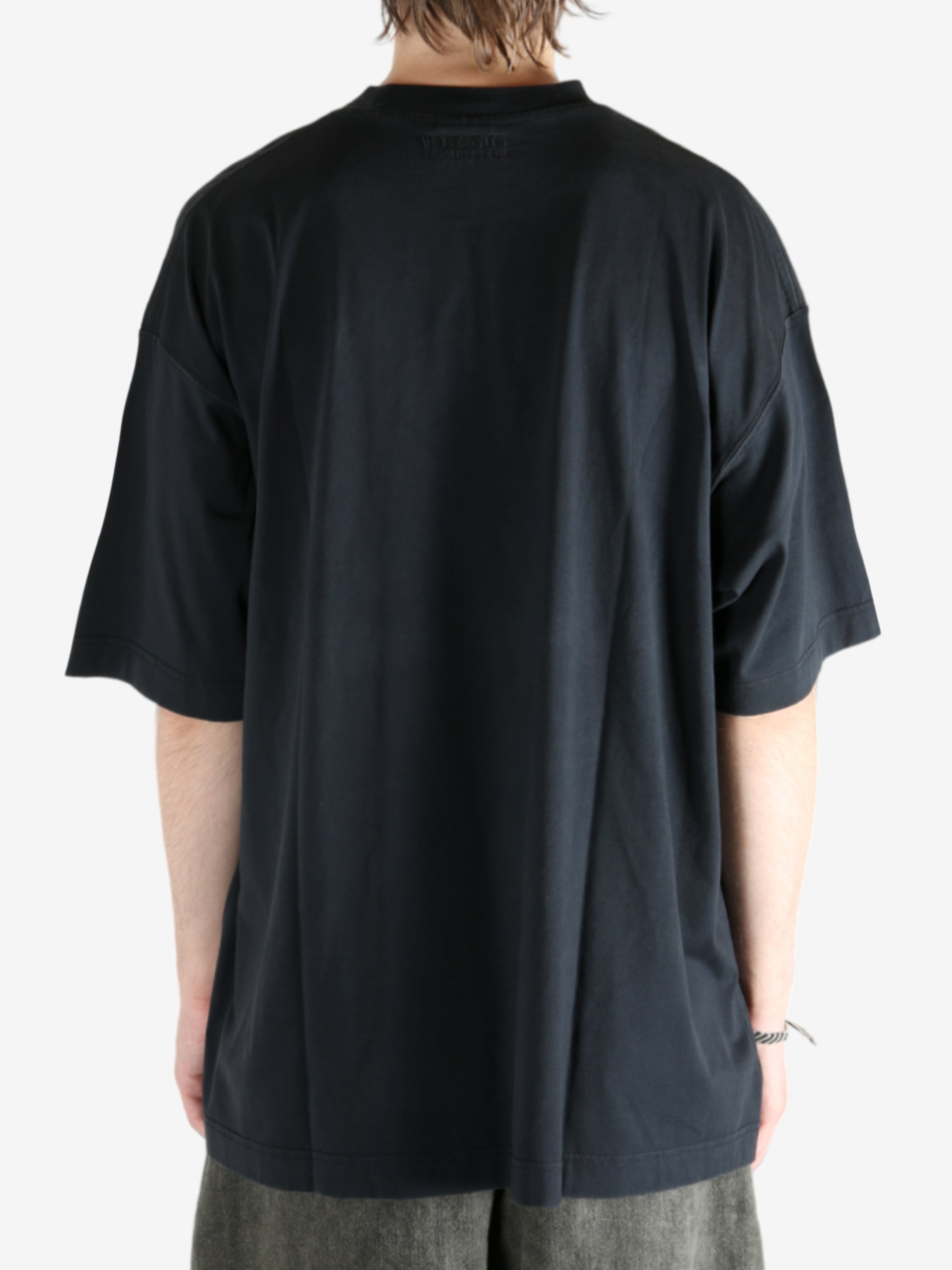 Black shirt worn by a person, showing the shirt fit