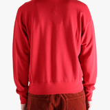 Red knitwear worn by a person, showing the knitwear's fit