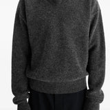 Black sweater worn by a person, showing the sweater's fit