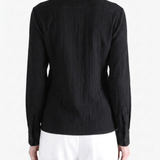 Black shirt worn by a person, showing the shirt fit