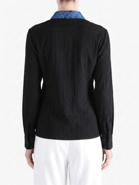 Black shirt worn by a person, showing the shirt fit