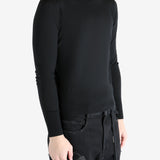 Black sweater worn by a person, showing the sweater's fit