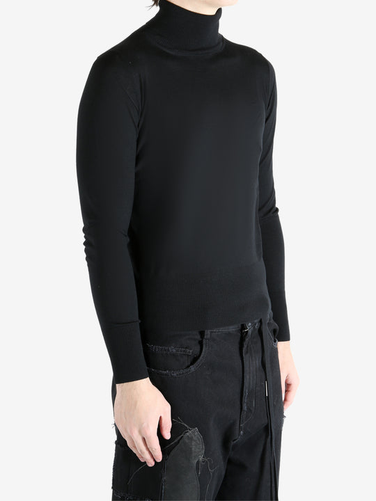 Black sweater worn by a person, showing the sweater's fit