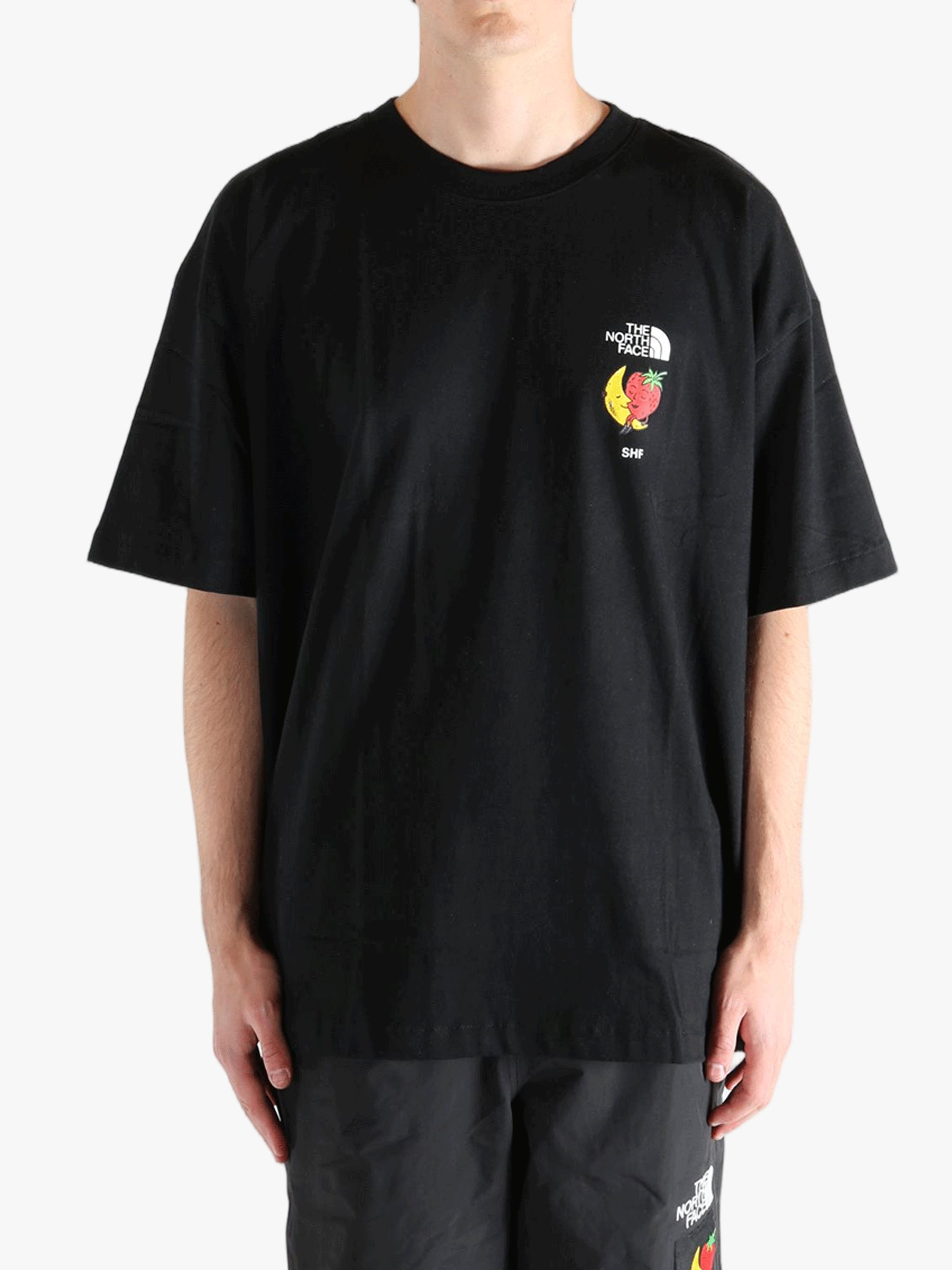 Black tee worn by a person, showing the tee fit