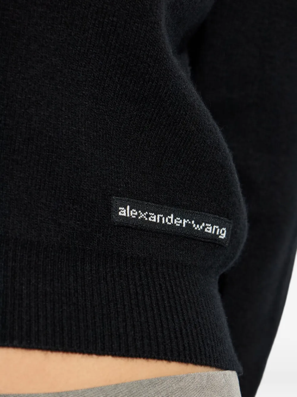 Close up of black knitwear, showing texture of the wool fabric