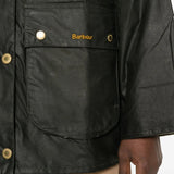 Close-up of a black jacket with gold buttons and 'Barbour' branding.
