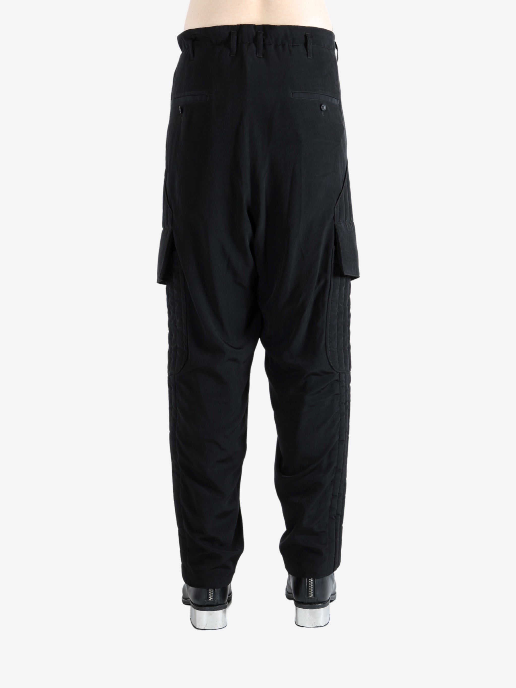 Black pants worn by a person, showing the pants' fit