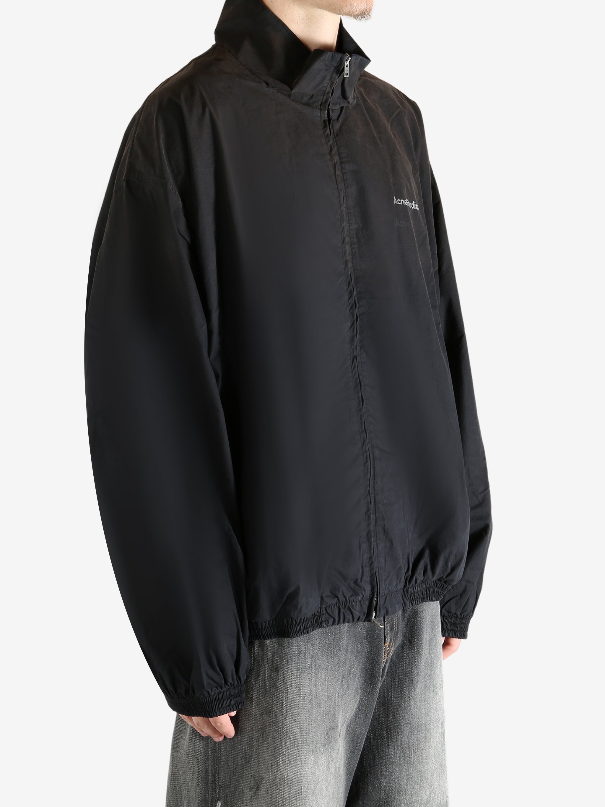 Black coat worn by a person, showing the coat's fit