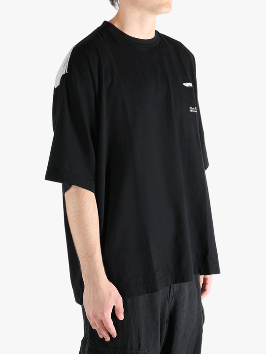 Black t-shirt worn by a person, showing the shirt's fit