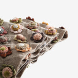 Close up of tan scarves, showing texture of the wool and cotton and linen fabric