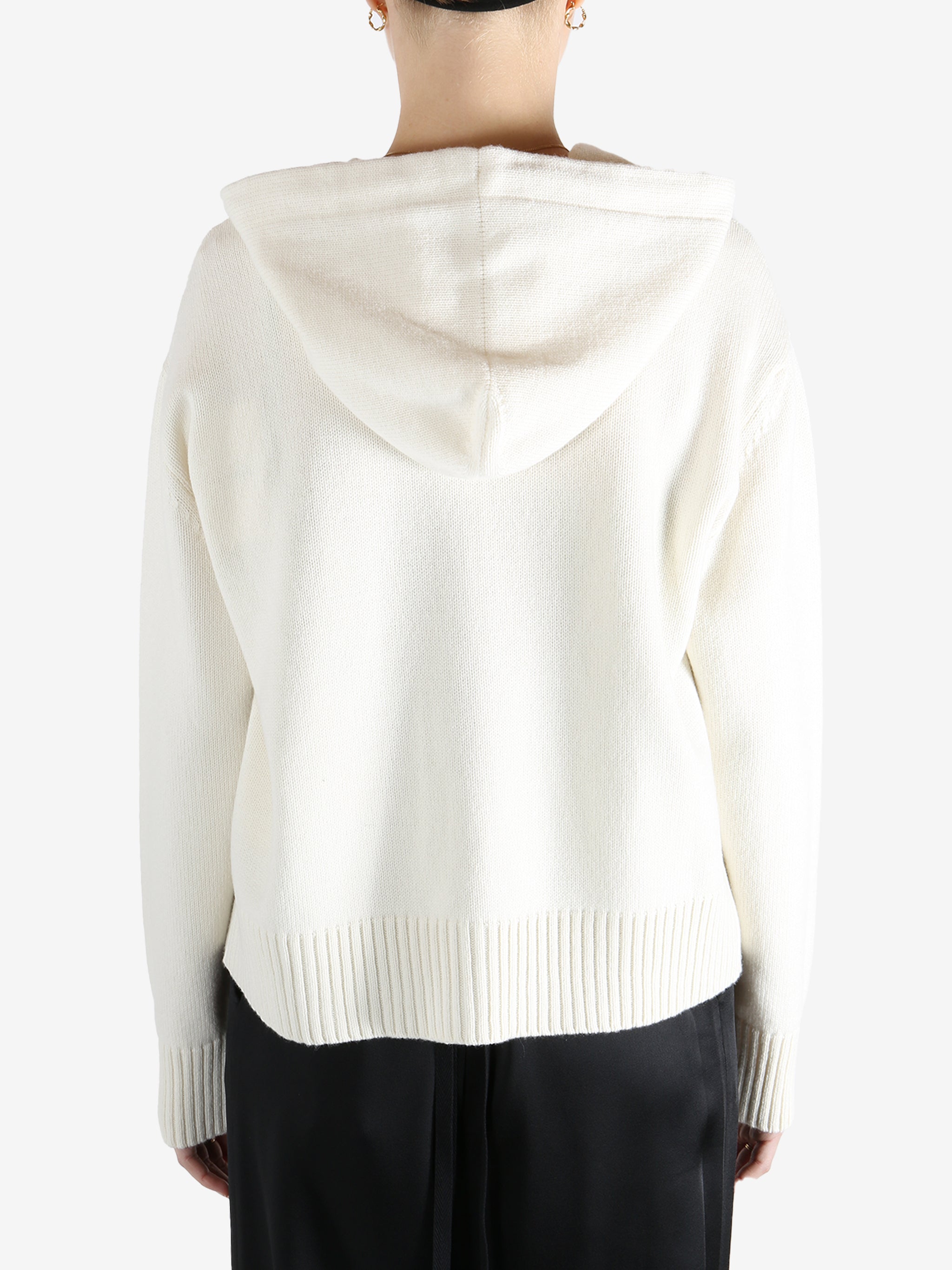 White knitwear worn by a person, showing the knitwear fit