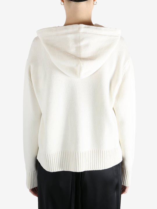 White knitwear worn by a person, showing the knitwear fit