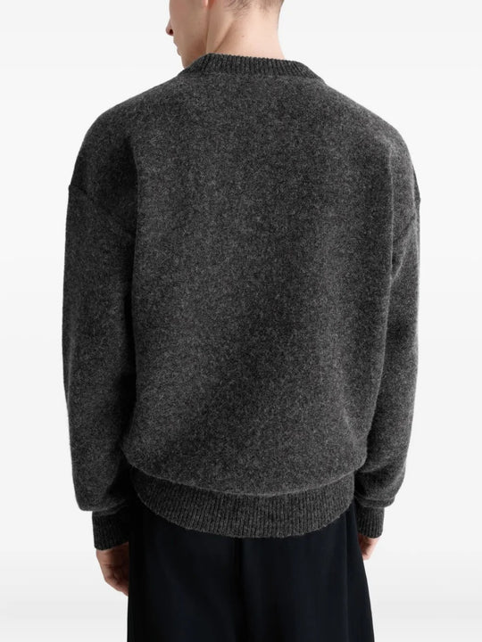 Black sweater worn by a person, showing the sweater's fit